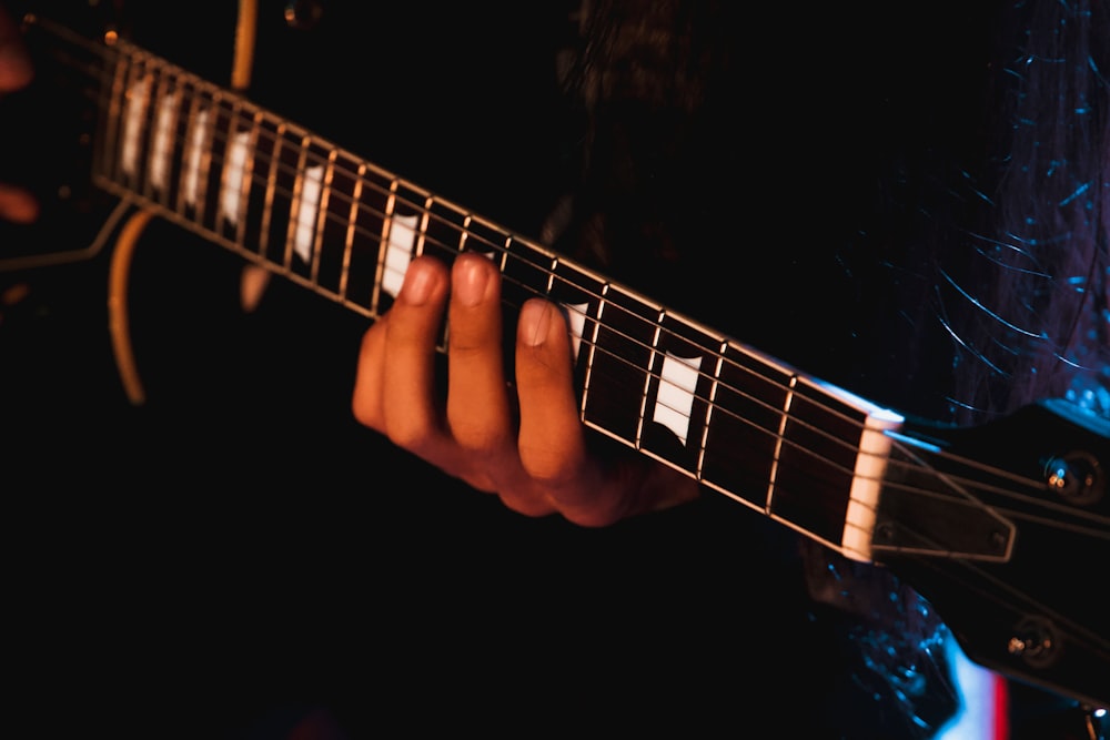 a hand playing a guitar