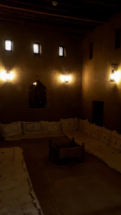 A beautifully arranged Arabic majlis with traditional cushions and low wooden tables in warm earth tones.