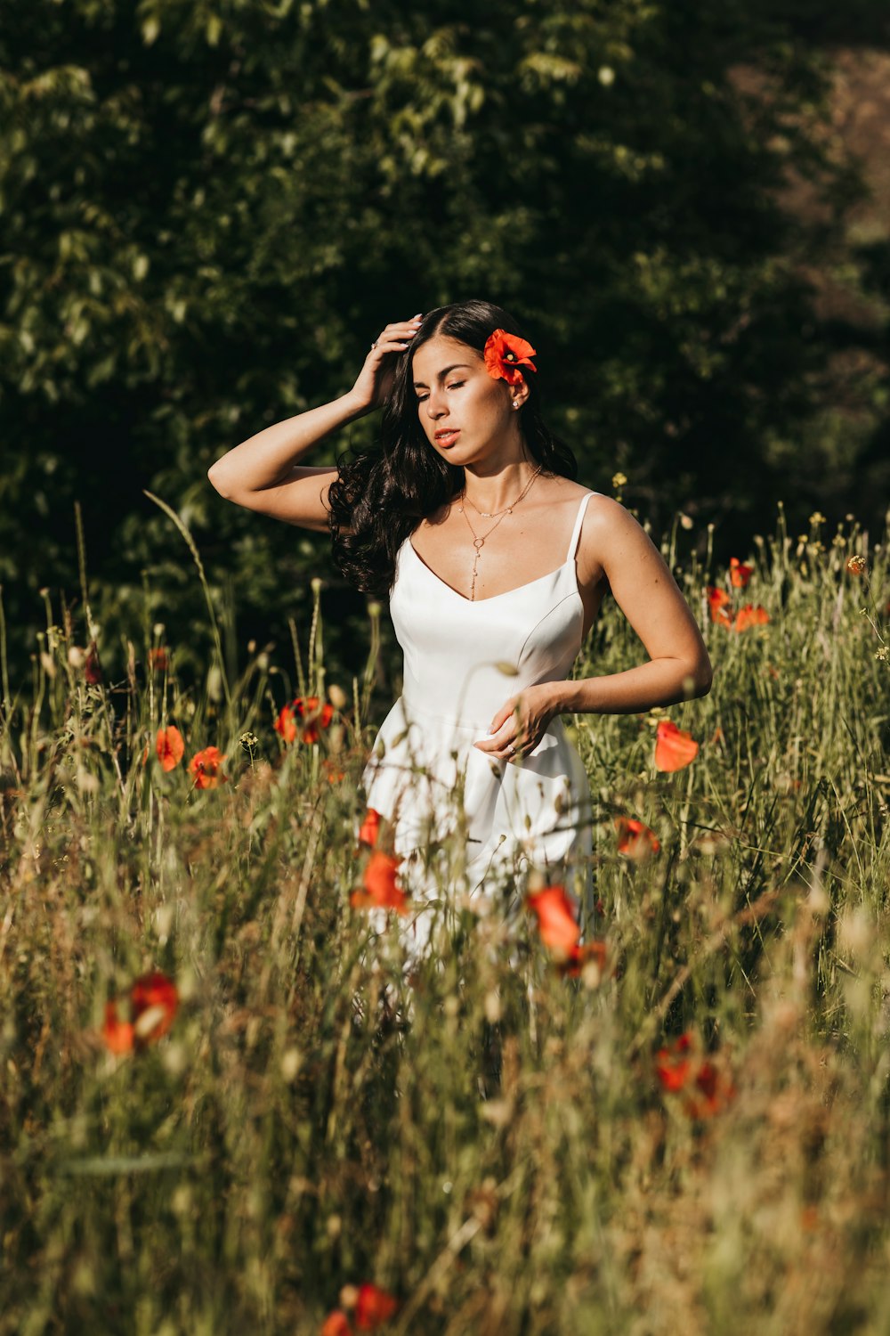 a person in a white dress standing in a field of flowers