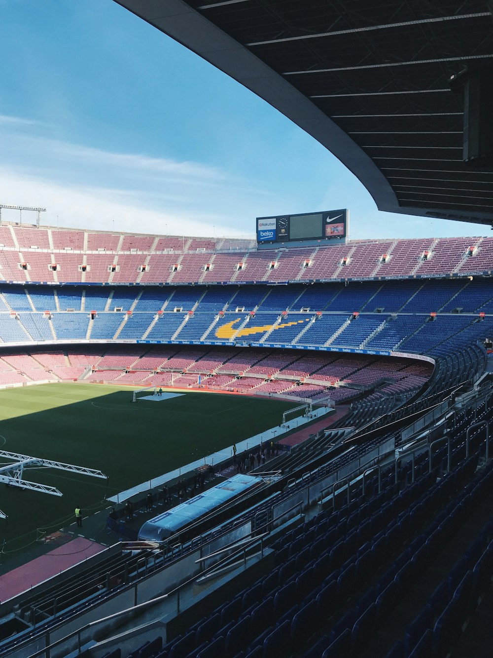 a stadium with a field and a field with people in it