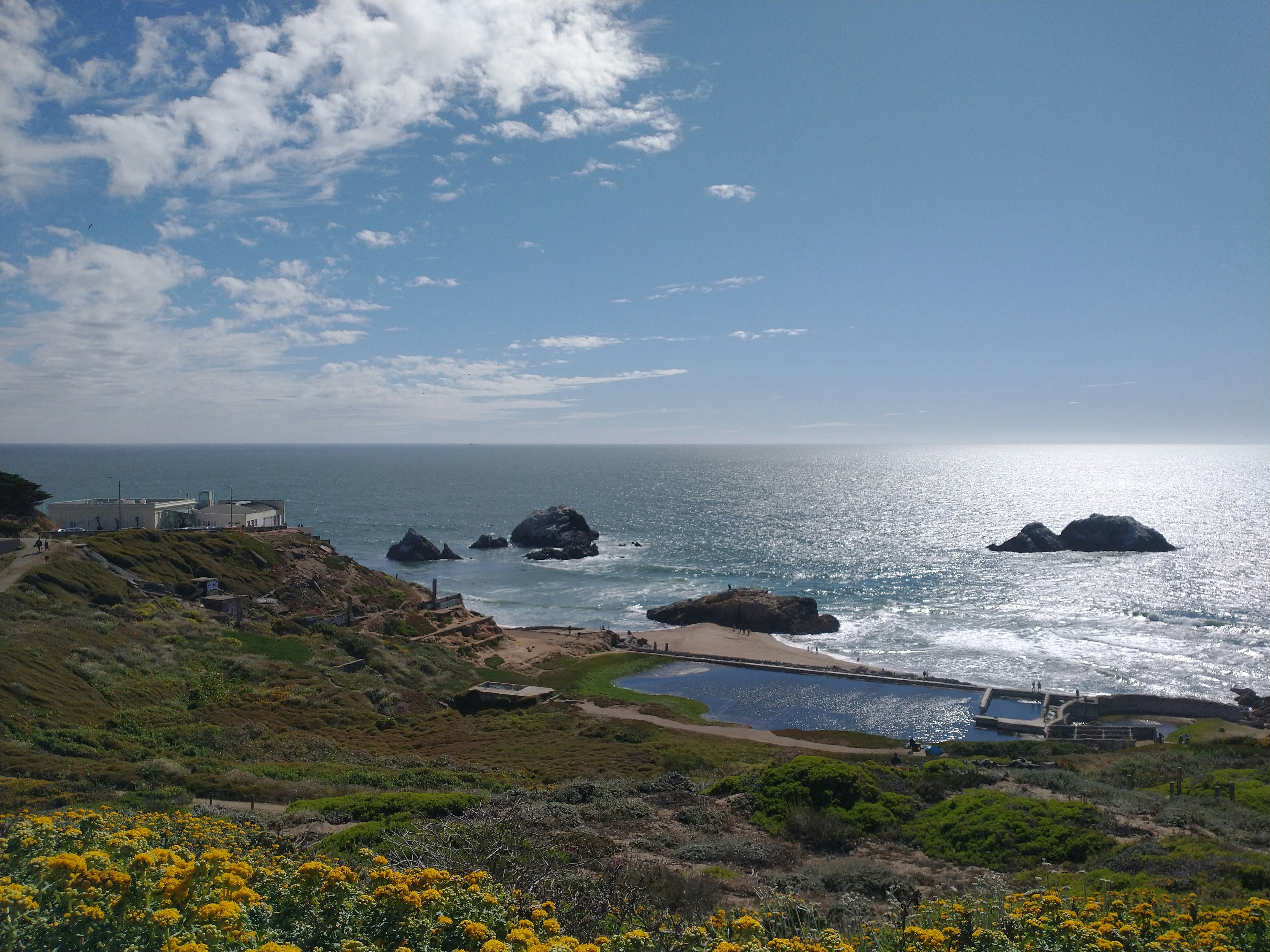 a rocky beach with a body of water in the background