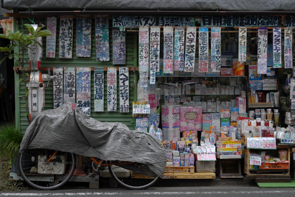 a bicycle parked in front of a store with posters on the wall