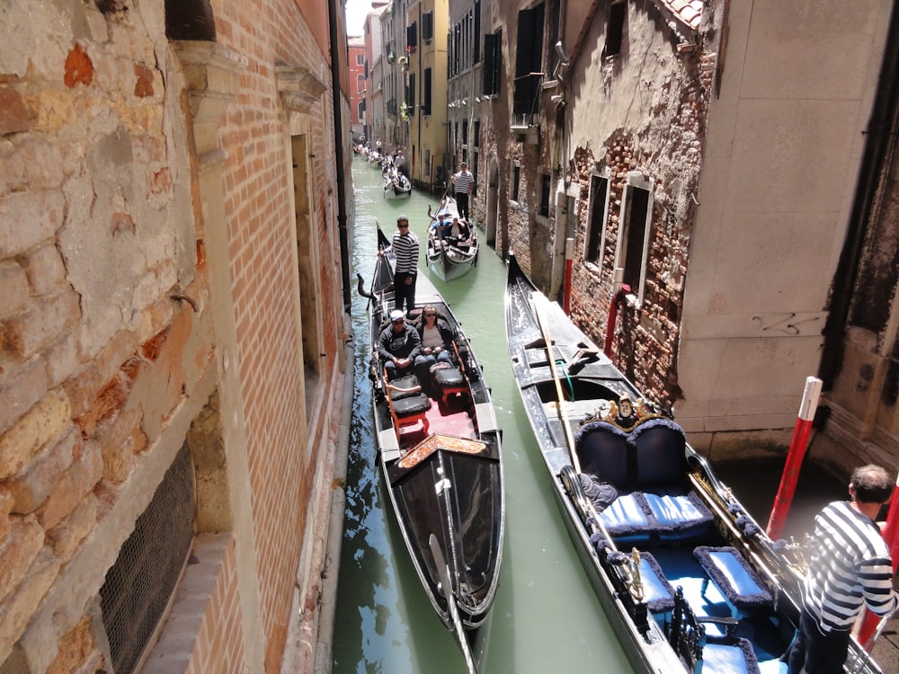 a group of boats are moving through a narrow canal