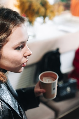 Lifestyle shot of a person relaxing in a comfortable streetwear ensemble, holding a coffee cup in a trendy urban café.