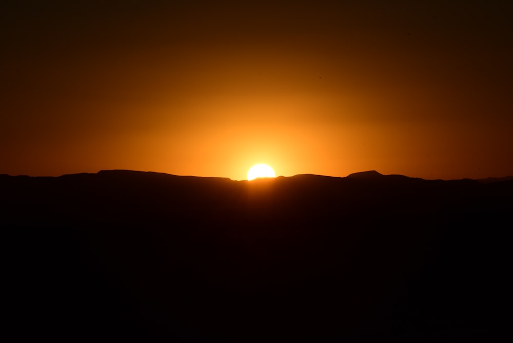 a sunset over a mountain