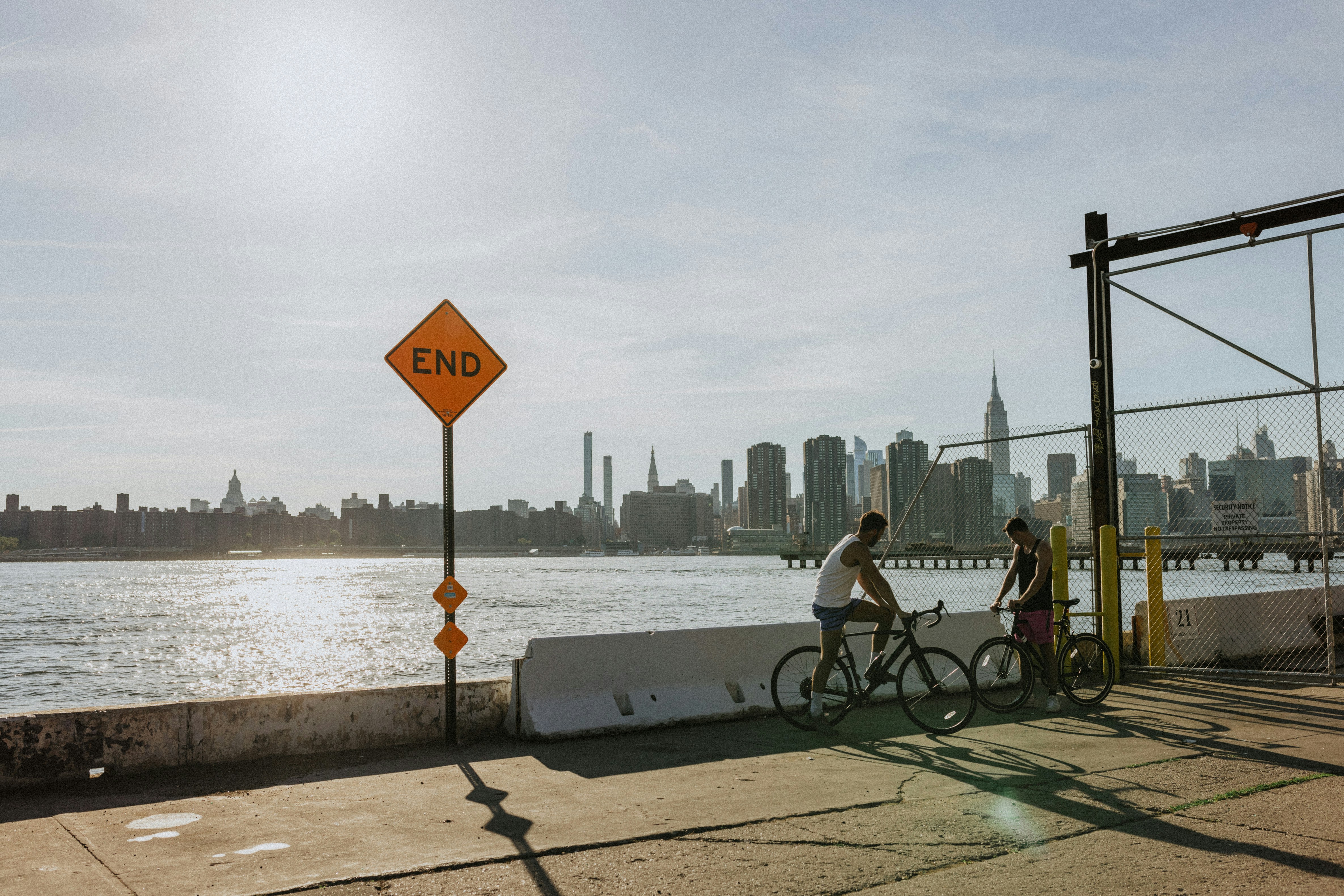 a couple of people ride bikes down a sidewalk