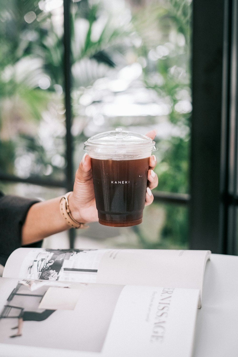 a person holding a glass of liquid