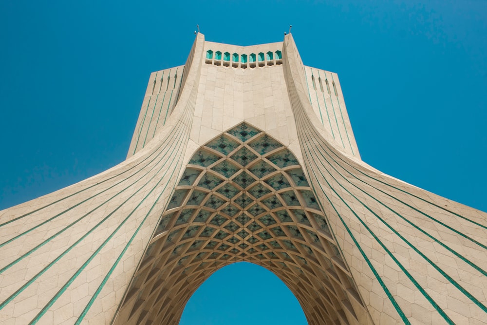 a tall building with a curved roof with Azadi Tower in the background
