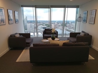 Cozy modern apartment living room with large windows and city view.