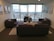 A bright and modern living room with large windows and stylish furniture, showcasing a comfortable apartment interior.