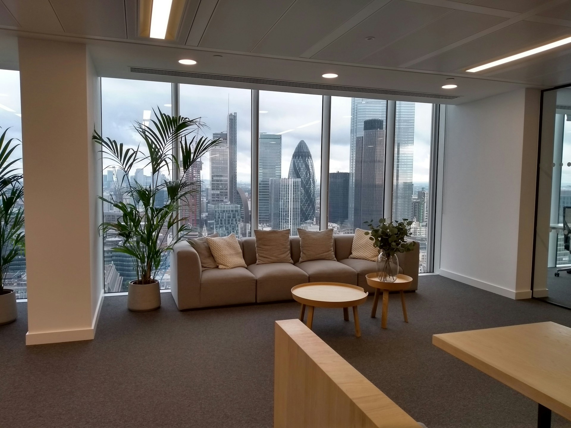 a room with a couch and a table with a plant in it
