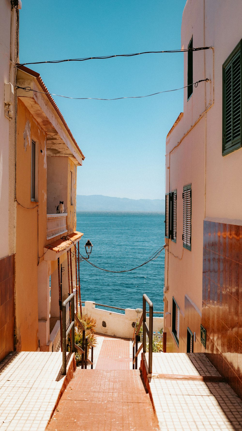 a street with buildings and a body of water in the background