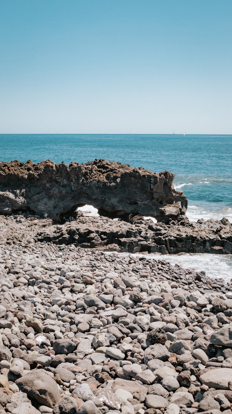 Una playa rocosa con agua de fondo
