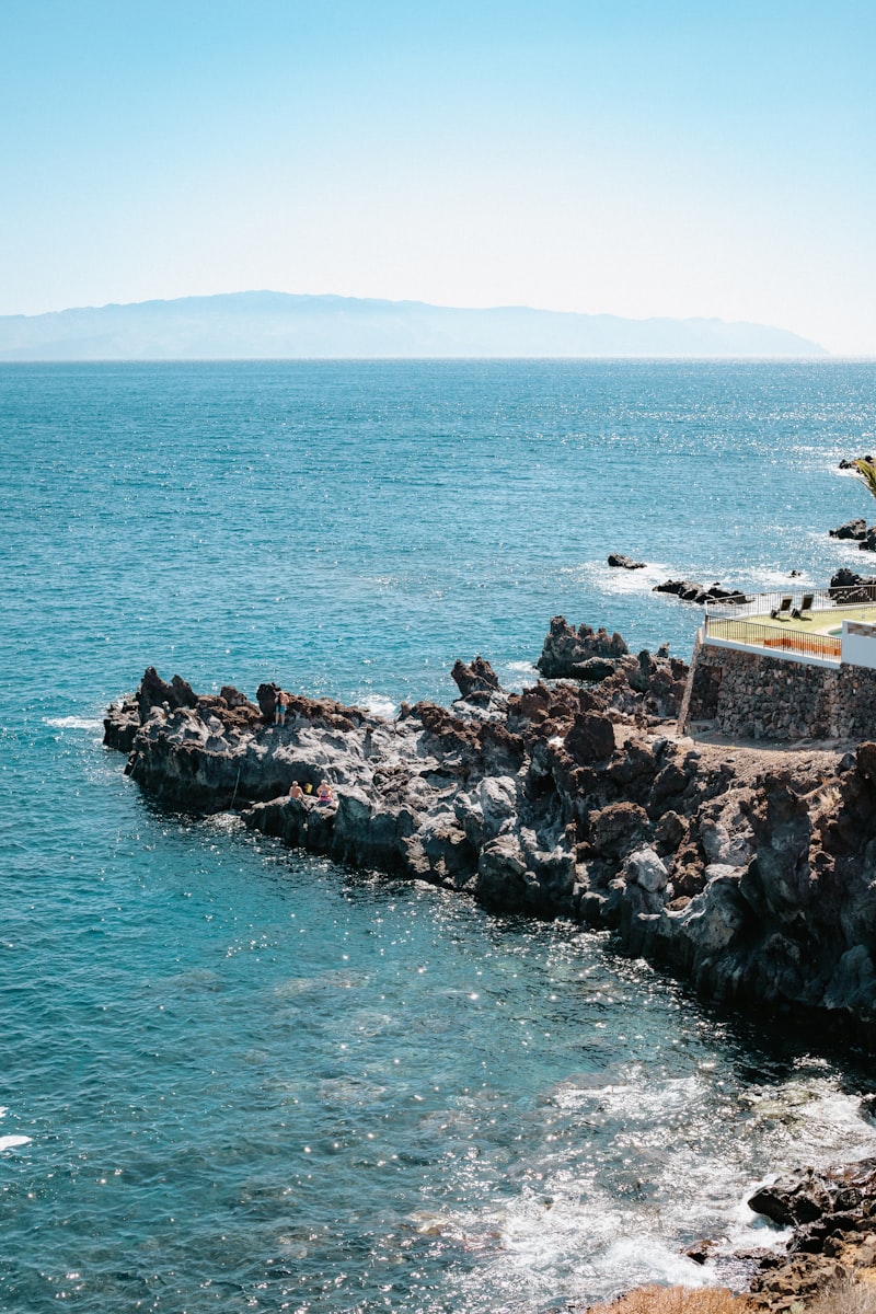 une côte rocheuse avec un bâtiment au bord de l'eau