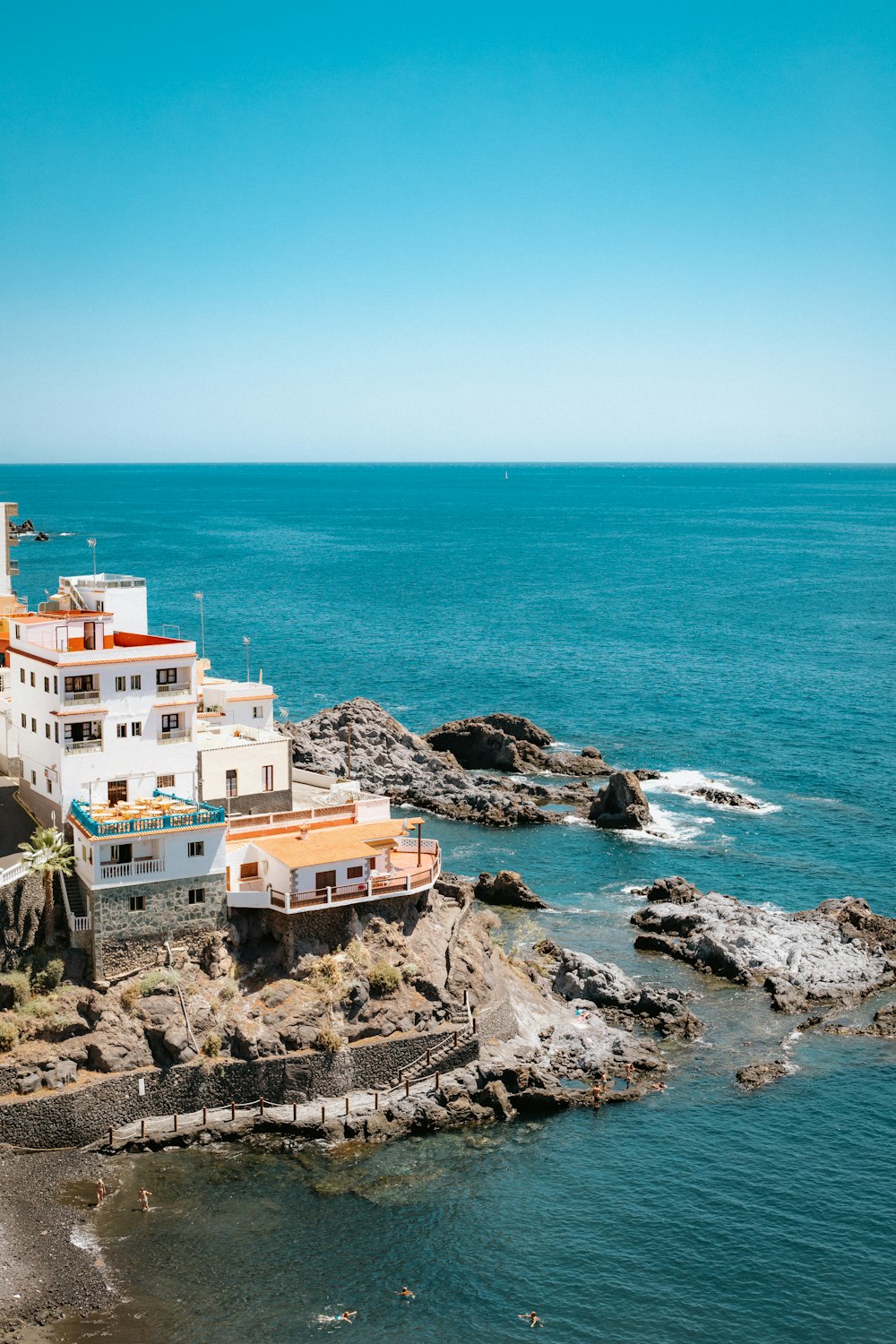 a building on a rocky cliff over the water