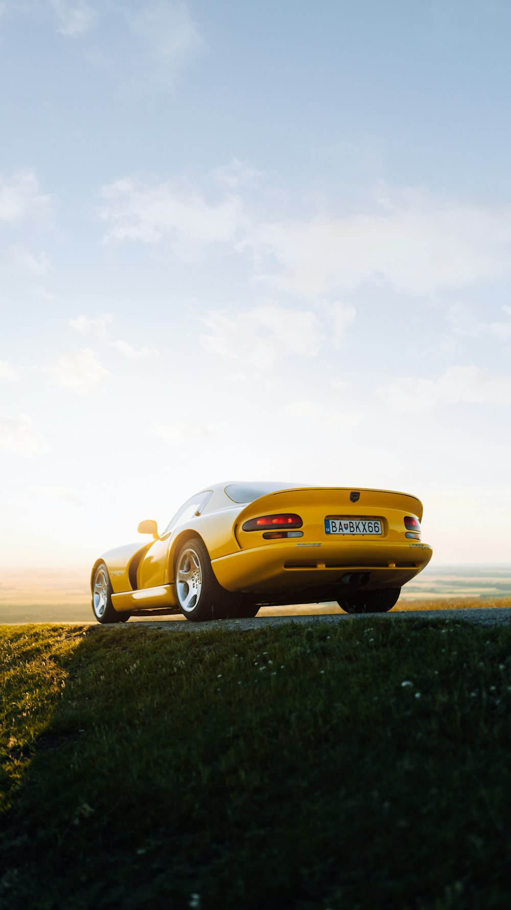 a yellow sports car on a road