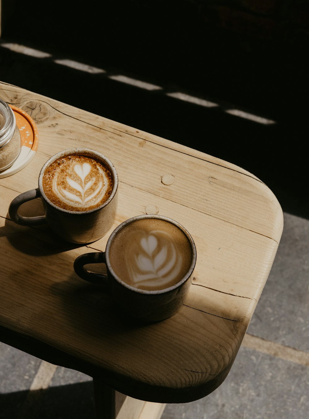 a couple of cups of coffee on a wooden table