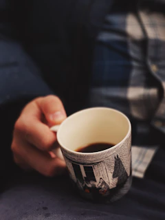 a hand holding a cup of coffee