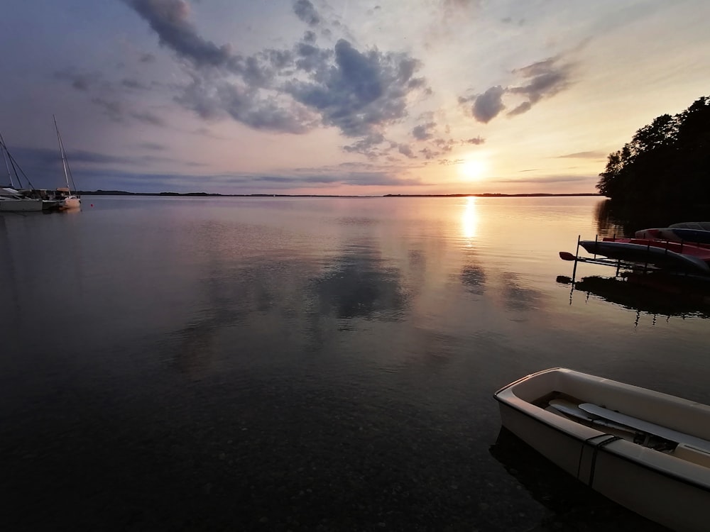 uno specchio d'acqua con barche e un tramonto