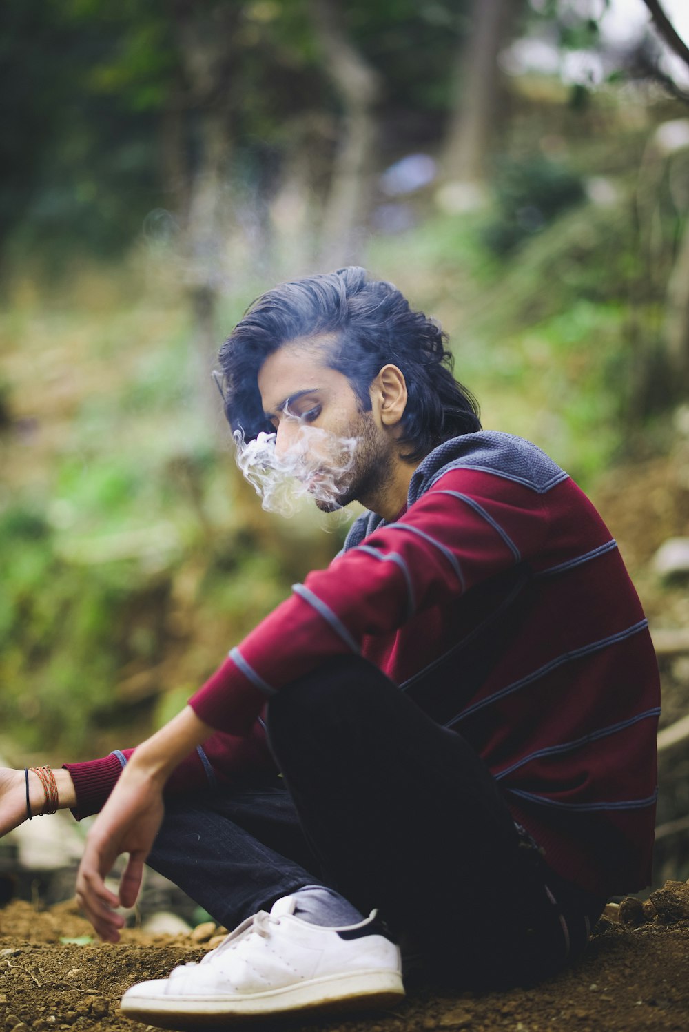 a person with a white face paint sitting on the ground