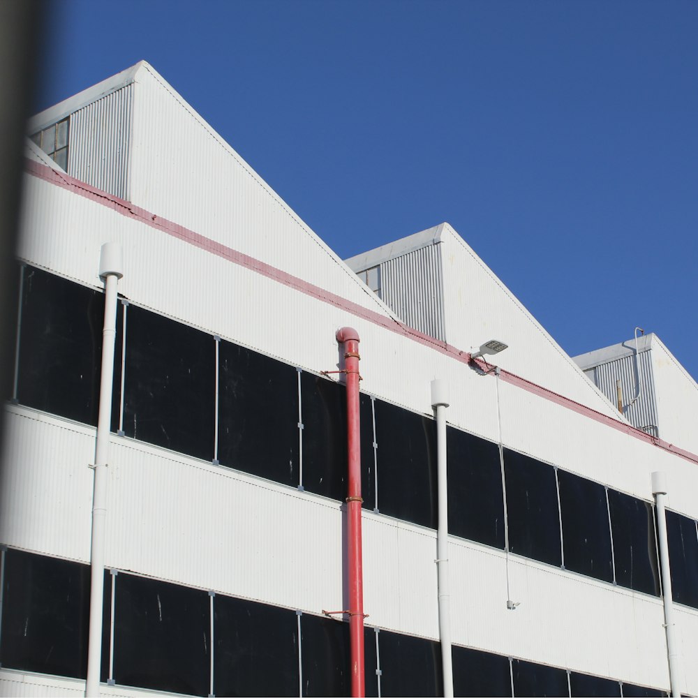 a white building with a red pole