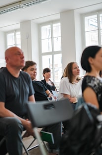 a group of people sitting in a room with laptops