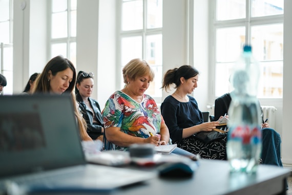 A diverse group of students engaged in a lively business workshop, with navy blue and electric blue accents in the background.