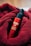 A red bottle labeled 'MARO 17 COLLAGEN SHOT' is nestled in a soft, textured red fabric. The bottle features a pump top, and the vibrant red of the fabric complements the glossy finish of the bottle.