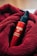 A red bottle labeled 'MARO 17 COLLAGEN SHOT' is nestled in a soft, textured red fabric. The bottle features a pump top, and the vibrant red of the fabric complements the glossy finish of the bottle.