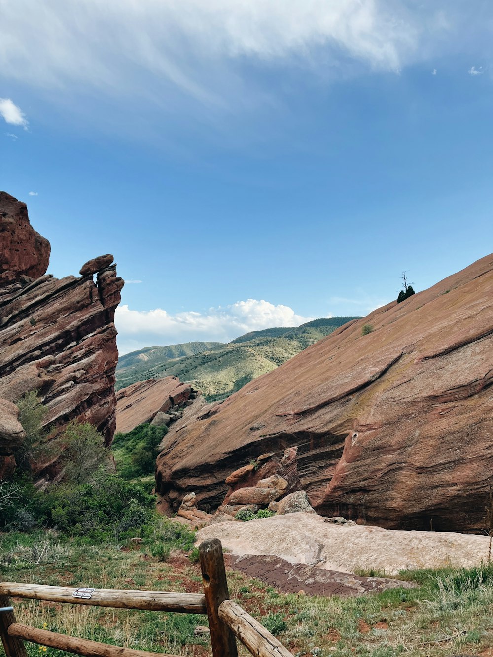 a person on a rock with Red Rocks Amphitheatre in the background