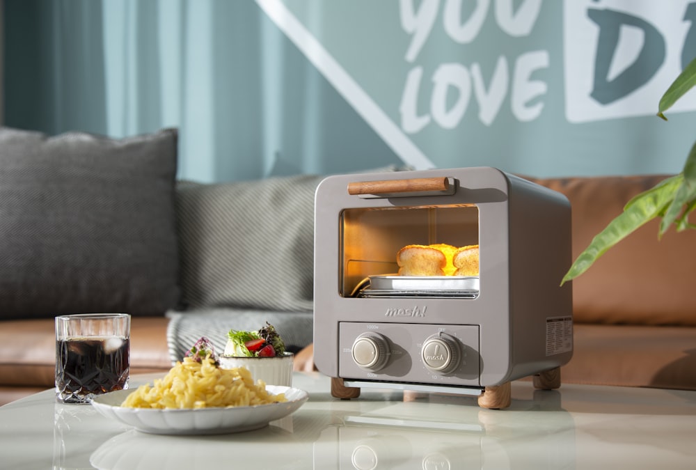 a toaster oven with a bowl of food and a glass of wine