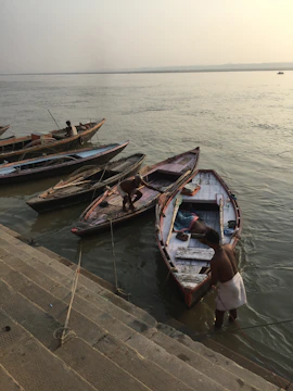 Early morning view of the Ganges river with boats and pilgrims in Varanasi.