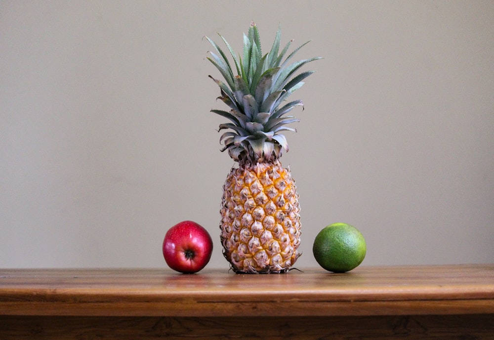 a pineapple and apples on a table