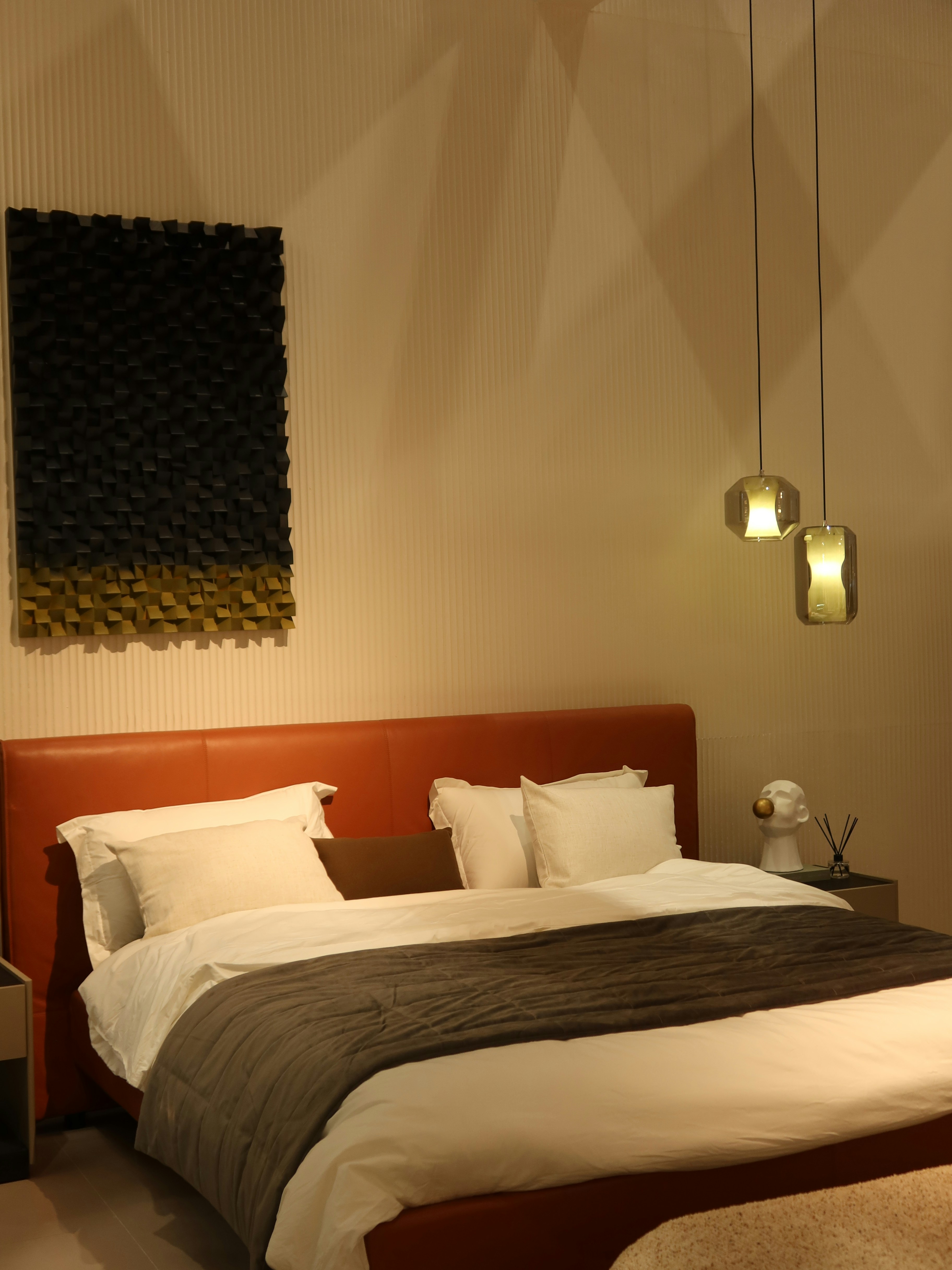 Modern bedroom with warm amber orange LED accent lighting on headboard wall, minimalist design, soft atmospheric glow