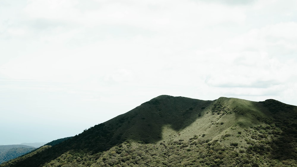 una collina erbosa con un cielo nuvoloso