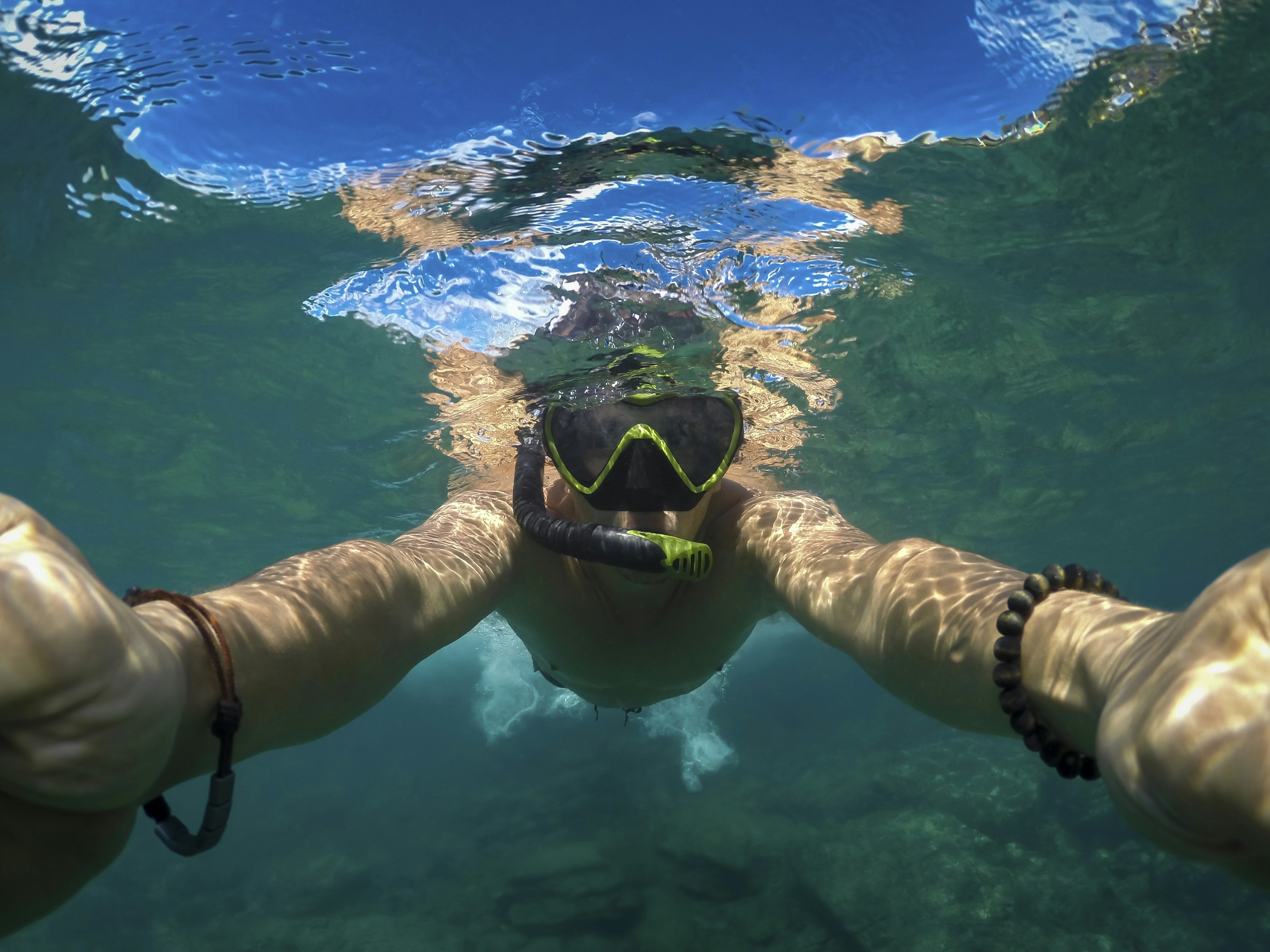 Snorkeler applying reef-safe sunscreen before entering the water
