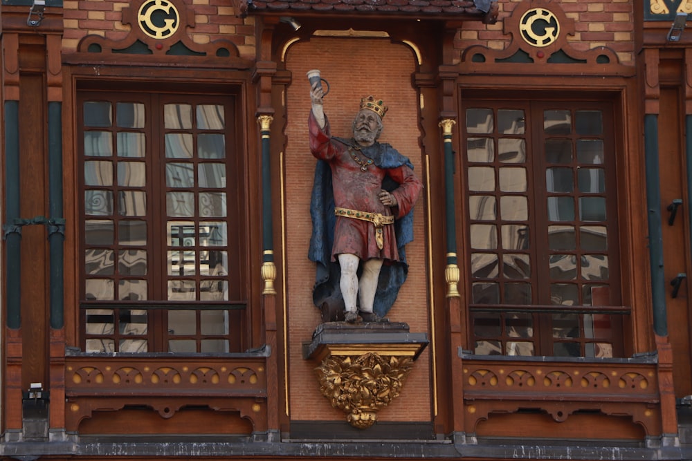a statue of a person holding a staff in front of a building