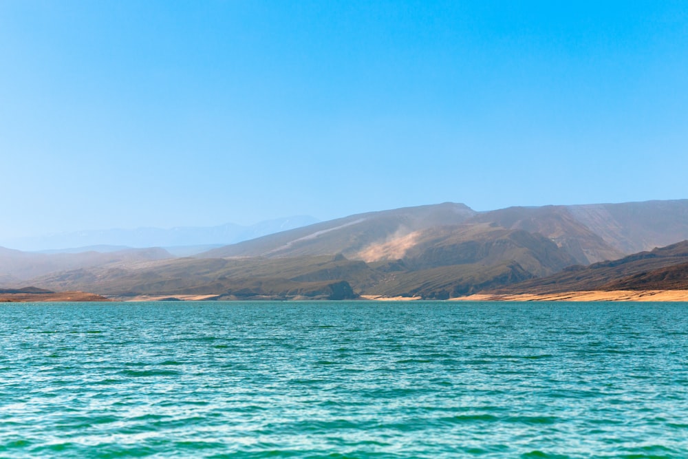 a body of water with hills in the background