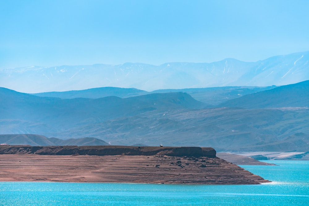 a body of water with mountains in the background