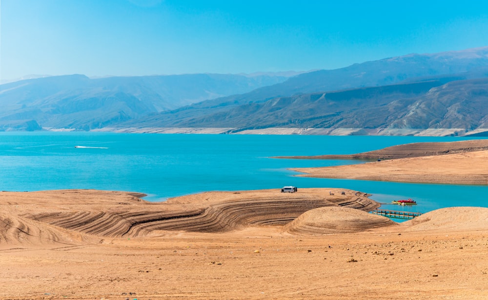 a car driving on a road next to a body of water