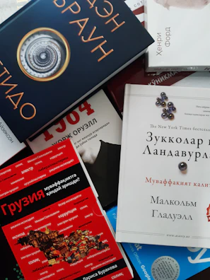 A quirky collection of odd and sods books stacked haphazardly with colorful, eclectic covers.