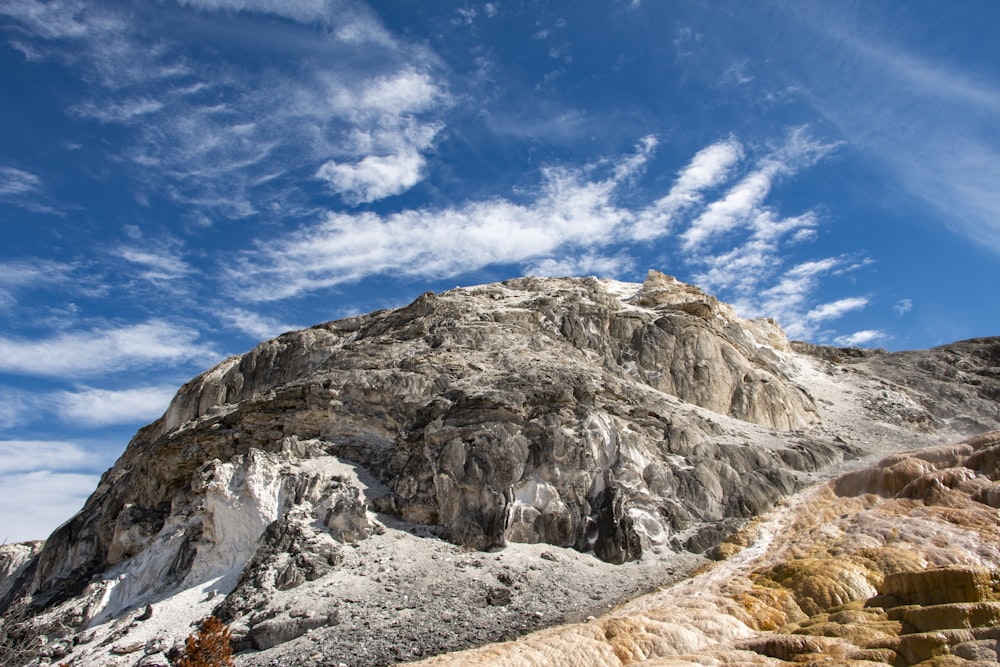 a rocky mountain with a blue sky