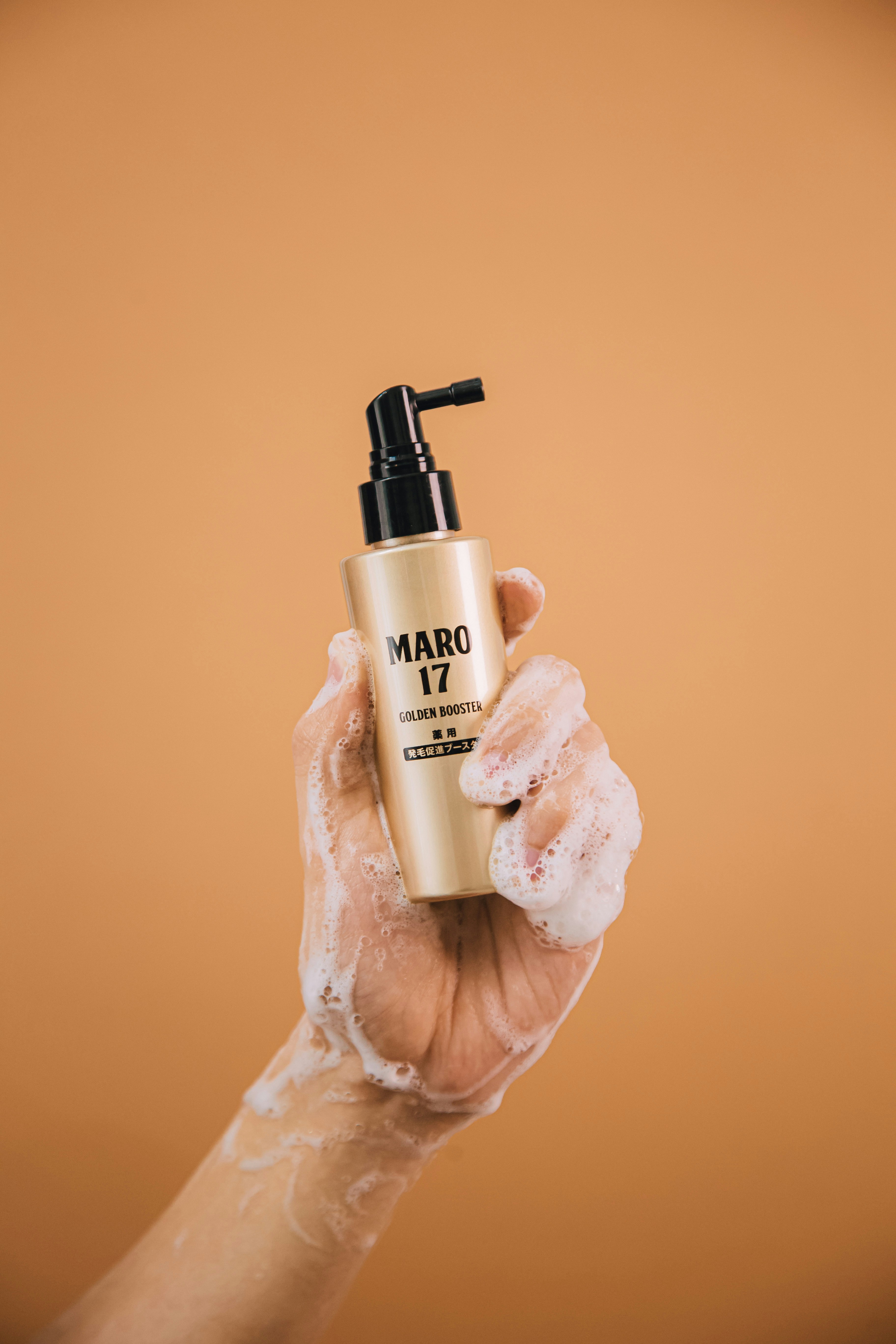 a hand holding a bottle of nail polish