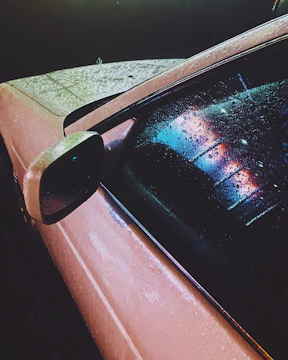 Close-up of a car’s wet, shiny paint reflecting sunlight after wash