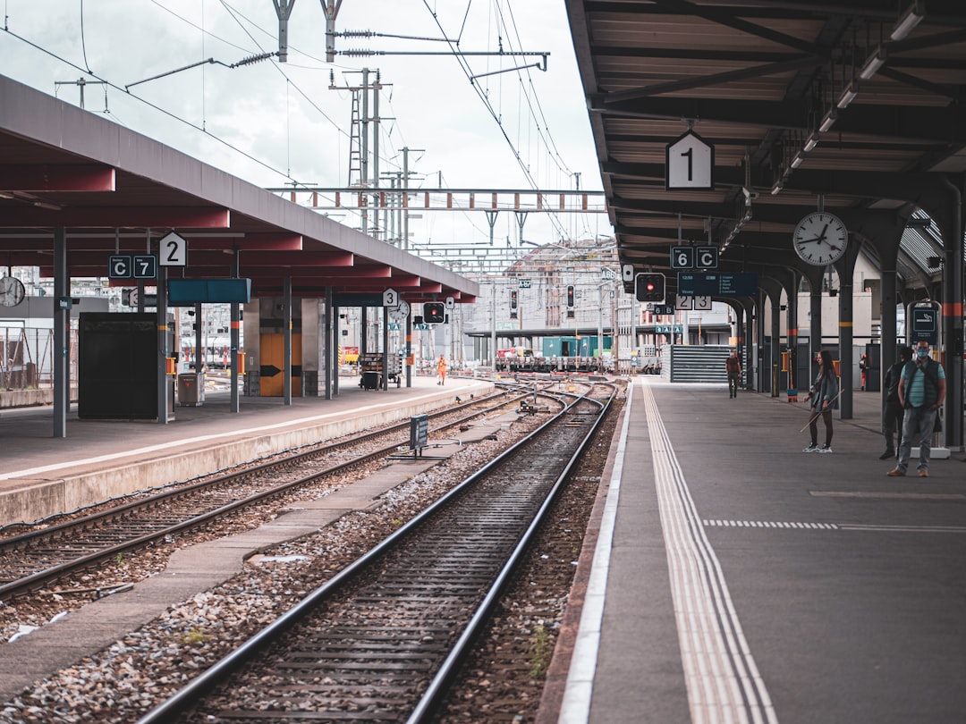 a train traveling down train tracks near a station,
