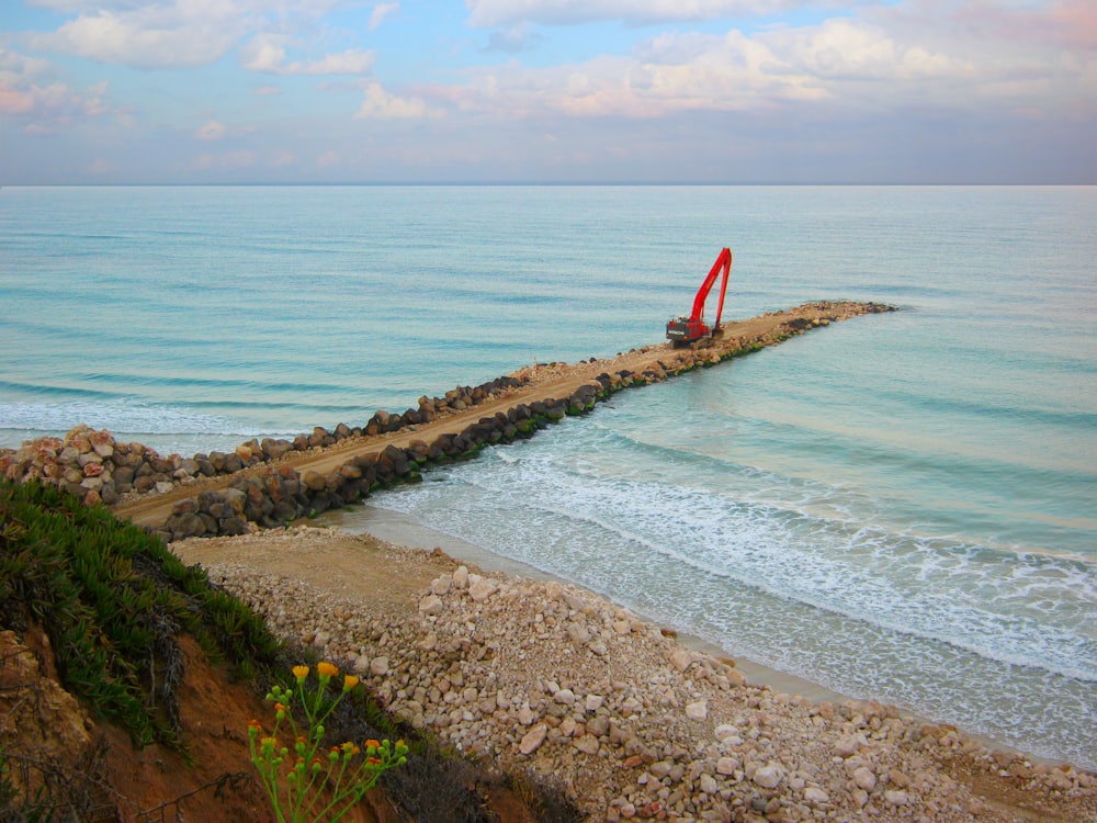 a rocky beach with a sailboat