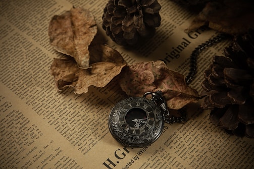 A rustic watch with a dial crafted from an antique coin, resting on a wooden surface.
