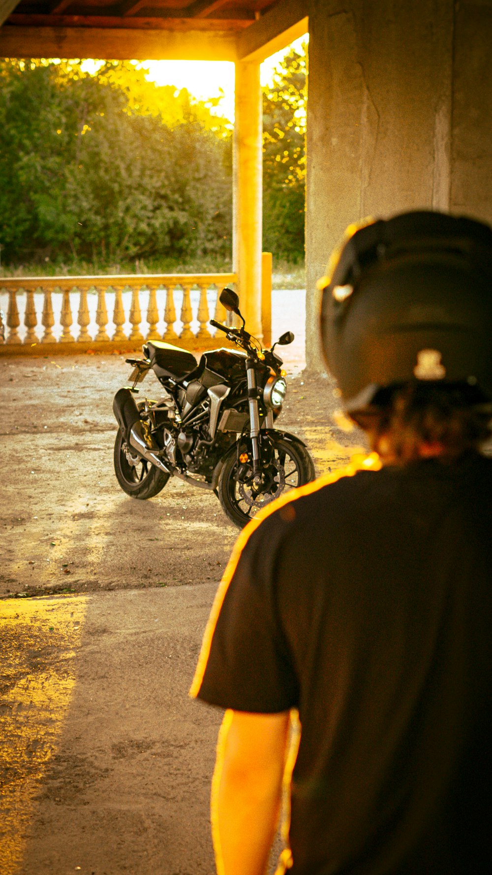 a person wearing a helmet looking at a motorcycle