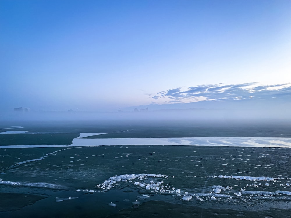 un plan d’eau avec de la glace et de la neige dessus