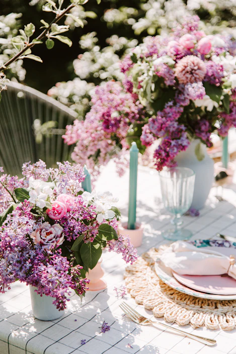A vibrant summer table setting with colorful tableware and fresh linen outdoors
